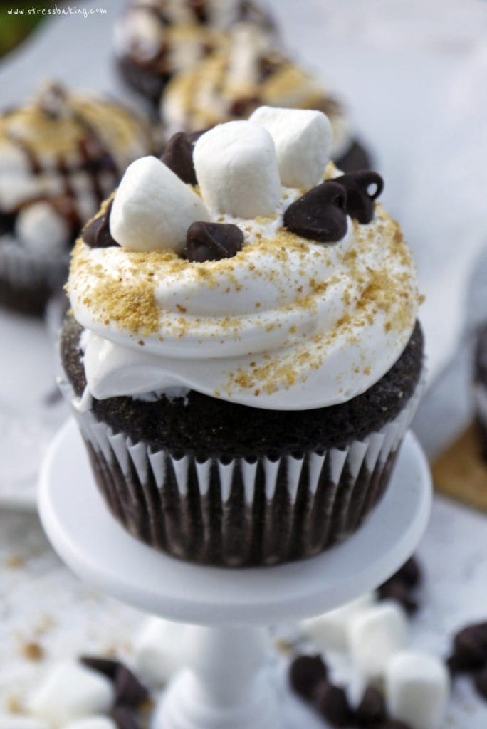 S'more Cupcakes: A favorite campfire treat turned cupcake! Moist chocolate cake is topped with marshmallow frosting and graham cracker crumbs. Get crazy and add some mini marshmallows, chocolate chips and syrup! | stressbaking.com