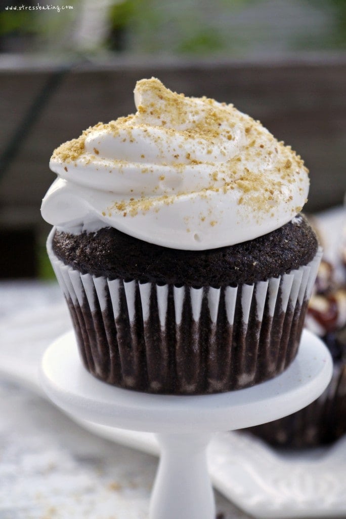 S'more Cupcakes: A favorite campfire treat turned cupcake! Moist chocolate cake is topped with marshmallow frosting and graham cracker crumbs. Get crazy and add some mini marshmallows, chocolate chips and syrup! | stressbaking.com