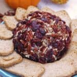 A cheeseball covered in dried cranberries and pecans
