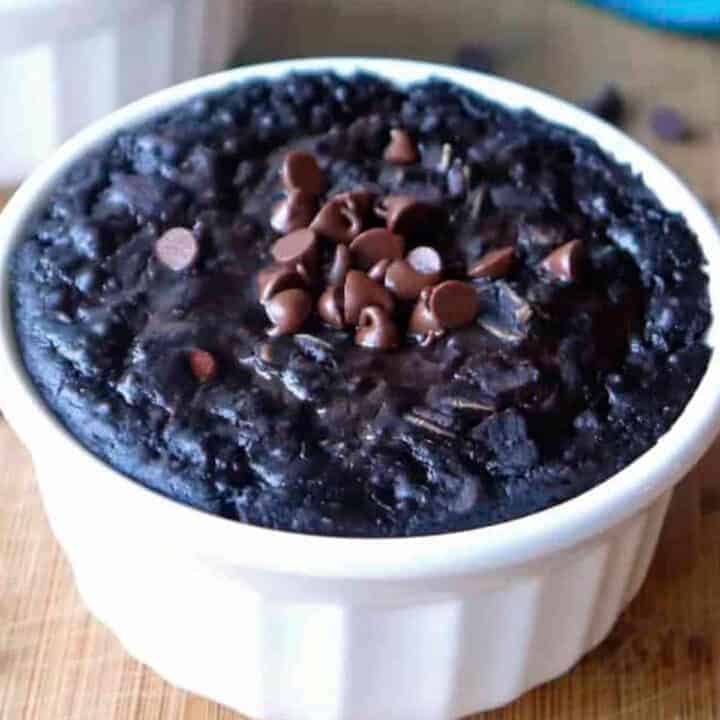 Dark chocolate baked oatmeal in a small white dish topped with mini chocolate chips