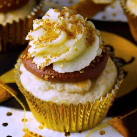 Vanilla cupcakes with layers of chocolate frosting and champagne frosting with gold sprinkles