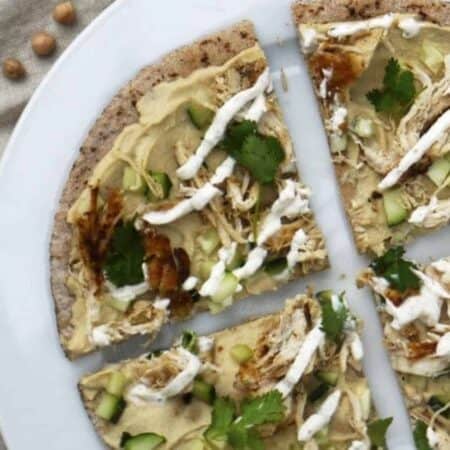 Pita wedges topped with hummus, shredded chicken, cilantro