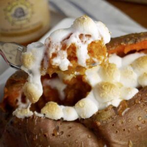 A forkful picking up the soft center of a twice baked sweet potato topped with marshmallows