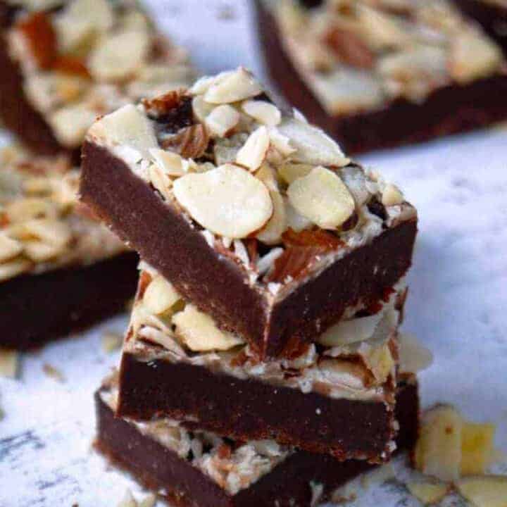 Chocolate fudge stacked and topped with sliced almonds