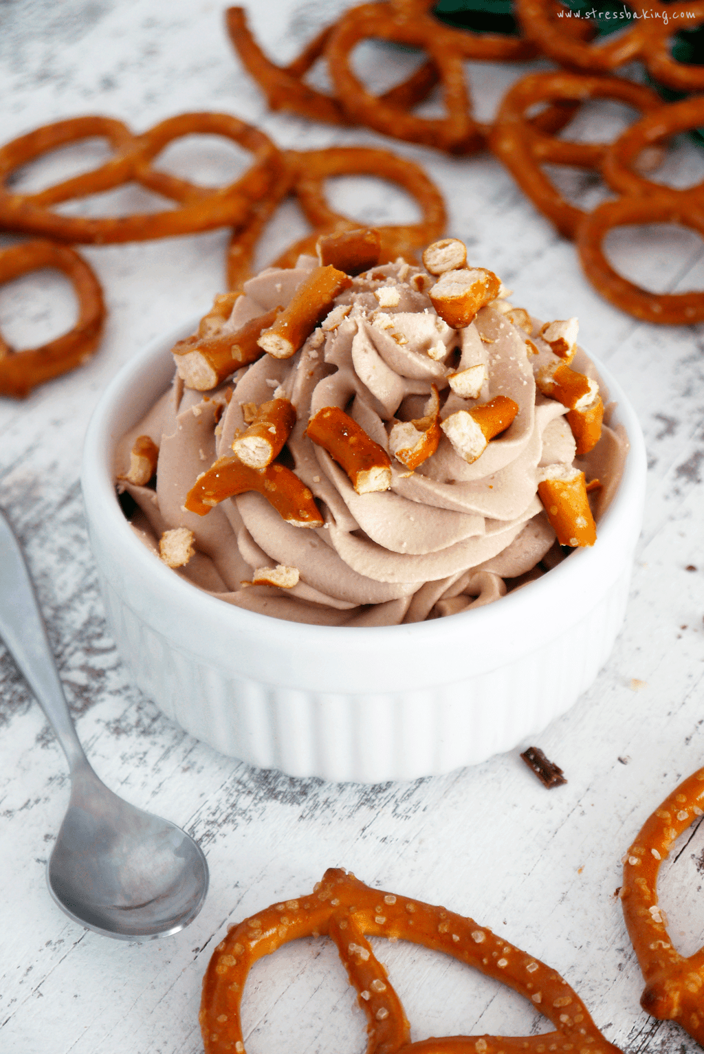 White ramekin filled with chocolate Guinness whipped cream and topped with pretzel pieces