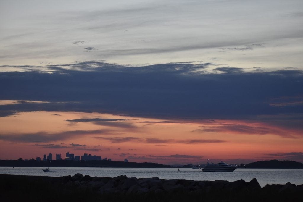 Sunset over Boston Harbor with a cruise ship in the foreground