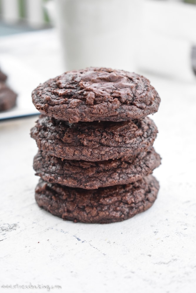 A stack of crinkled chocolate cookies on a white surface