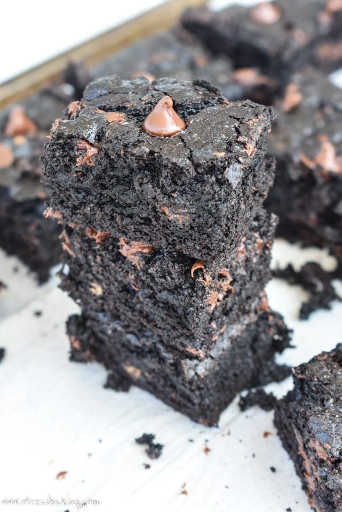 Stack of three thick, chocolatey brownies with melted chocolate chips