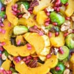 Roasted Delicata Squash and Brussels Sprouts: A fall side dish that will brighten any meal! Roasted delicata squash and brussels sprouts are topped with pomegranate arils for gorgeous pops of color. | stressbaking.com
