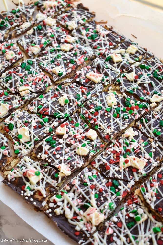 Christmas Crack: Warning: This is SUPER addictive! Saltines are covered with an easy caramel sauce, two types of chocolate, crushed and chopped peppermint, and assorted holiday sprinkles. This is absolute holiday treat perfection. | stressbaking.com #christmasdessert #christmastreat #holidaydessert #holidaytreat
