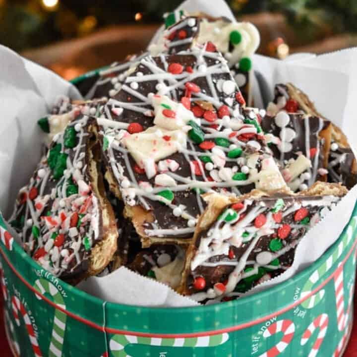 A holiday tin filled with festively decorated chocolate bark