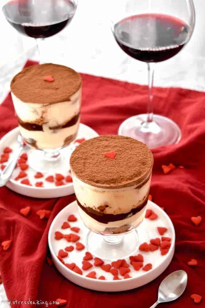 Two trifle dishes full of tiramisu decorated with red heart sprinkles