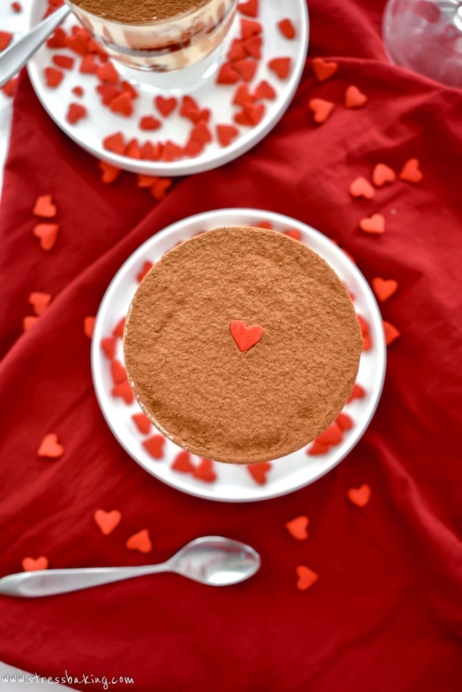 Closeup of a heart sprinkle on top of a trifle jar of tiramisu topped with cocoa powder