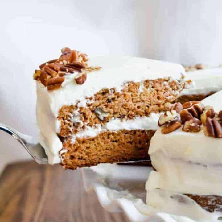A slice of carrot cake being lifted with a cake server