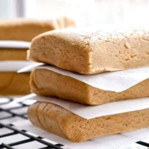 Honey almond protein bars stacked between parchment paper