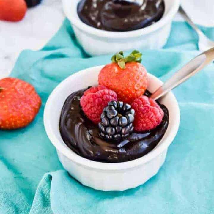 Paleo Chocolate Avocado Pudding in a white bowl with fresh berries