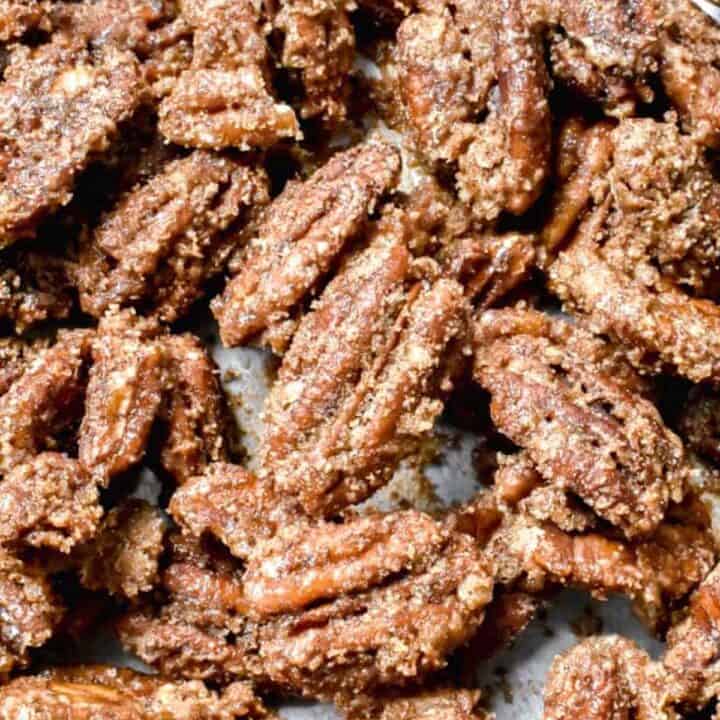 Scattered candied pecans on a baking sheet
