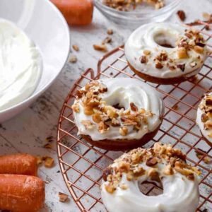 Carrot cake donuts topped with cream cheese icing and chopped nuts