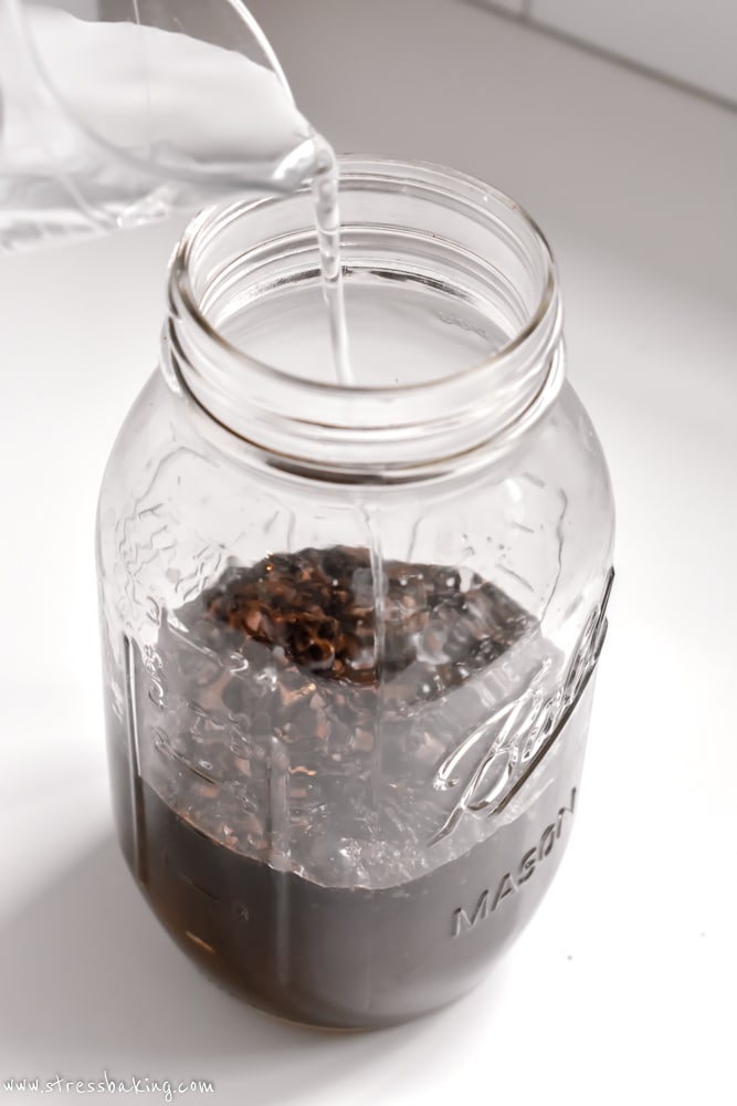 Water being poured into a mason jar of coffee grounds