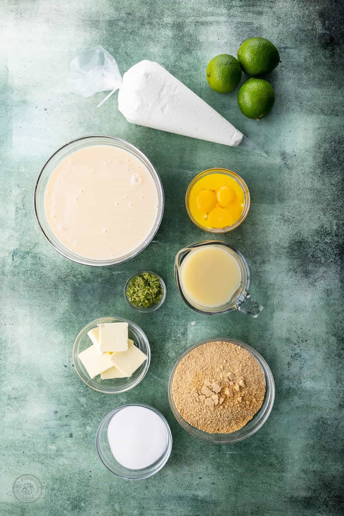 Ingredients for key lime pie on a greenish surface