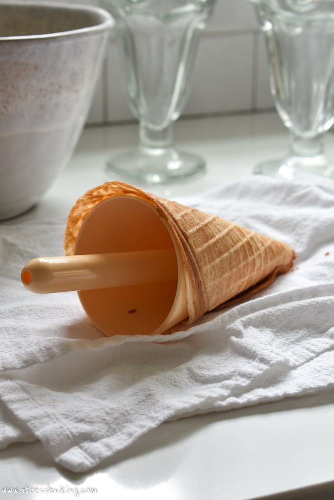 Waffle cone wrapped around a cone form on a white towel