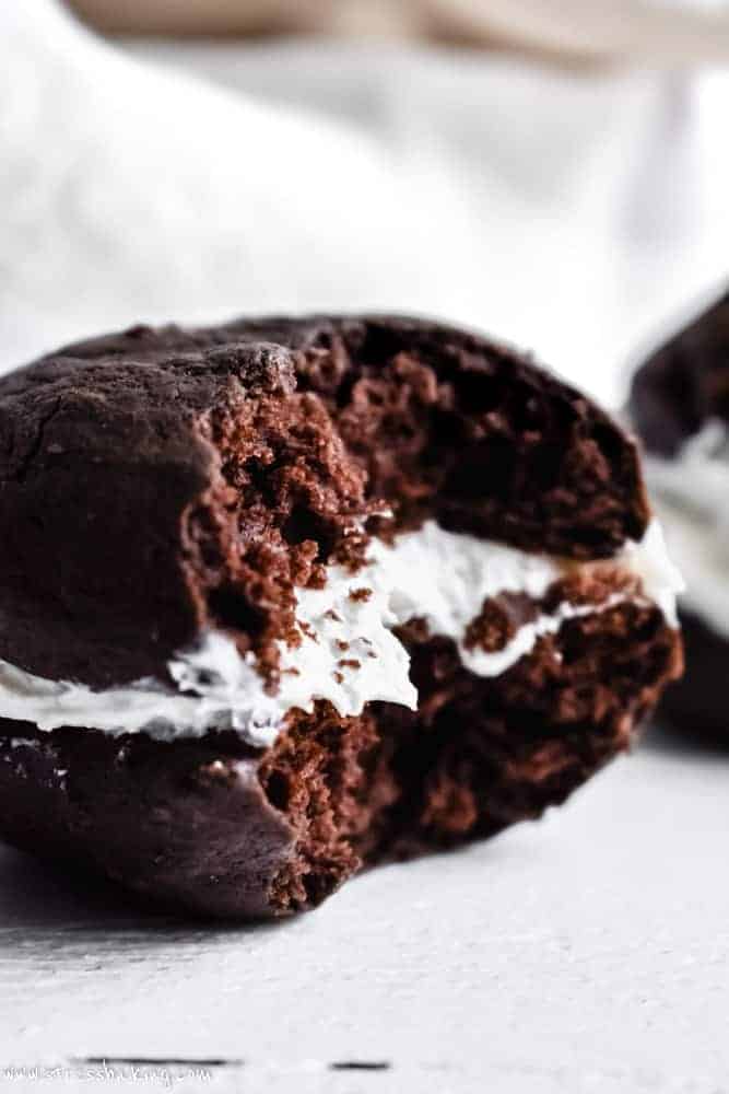 Close up of a chocolate whoopie pie with a bite taken out