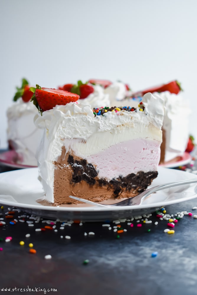 A slice of Neapolitan Crunch Ice Cream Cake on a white plate showing all the different layers