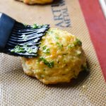 Copycat Red Lobster Cheddar Bay Biscuit being brushed with butter