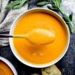 Overhead shot of vibrant orange butternut squash soup on a spoon