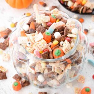 Halloween Puppy Chow in a clear pumpkin shaped bowl