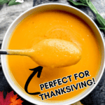 Butternut squash soup in a white bowl with a spoonful being lifted out