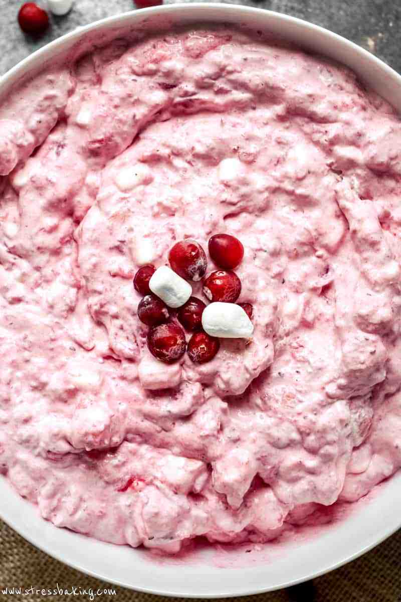 Overhead shot of vibrant pink cranberry fluff topped with marshmallows and cranberries