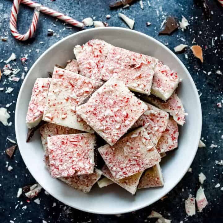 Overhead shot of peppermint bark pieces stacked on top of each other in a white bowl