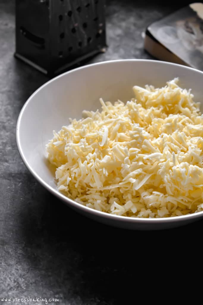 A white bowl of shredded cheese