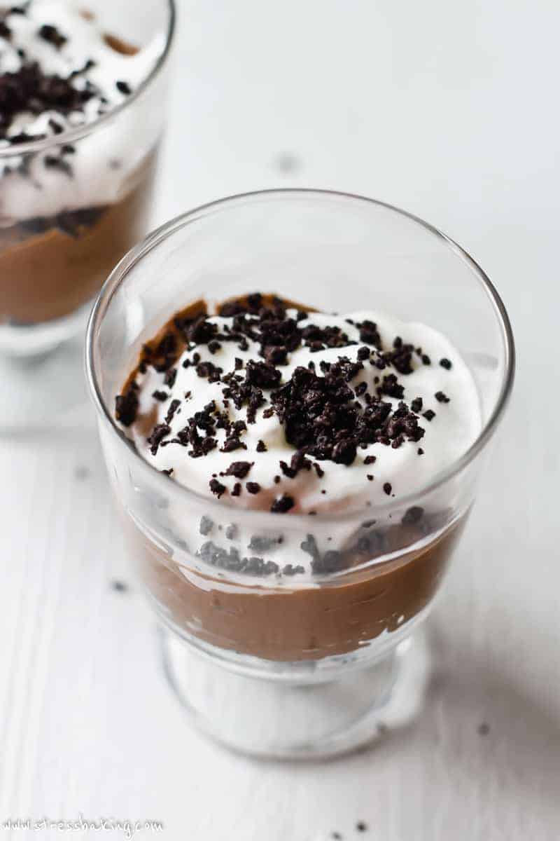 A trifle dish with layers of Nutella mousse, whipped cream and topped with crushed Oreos