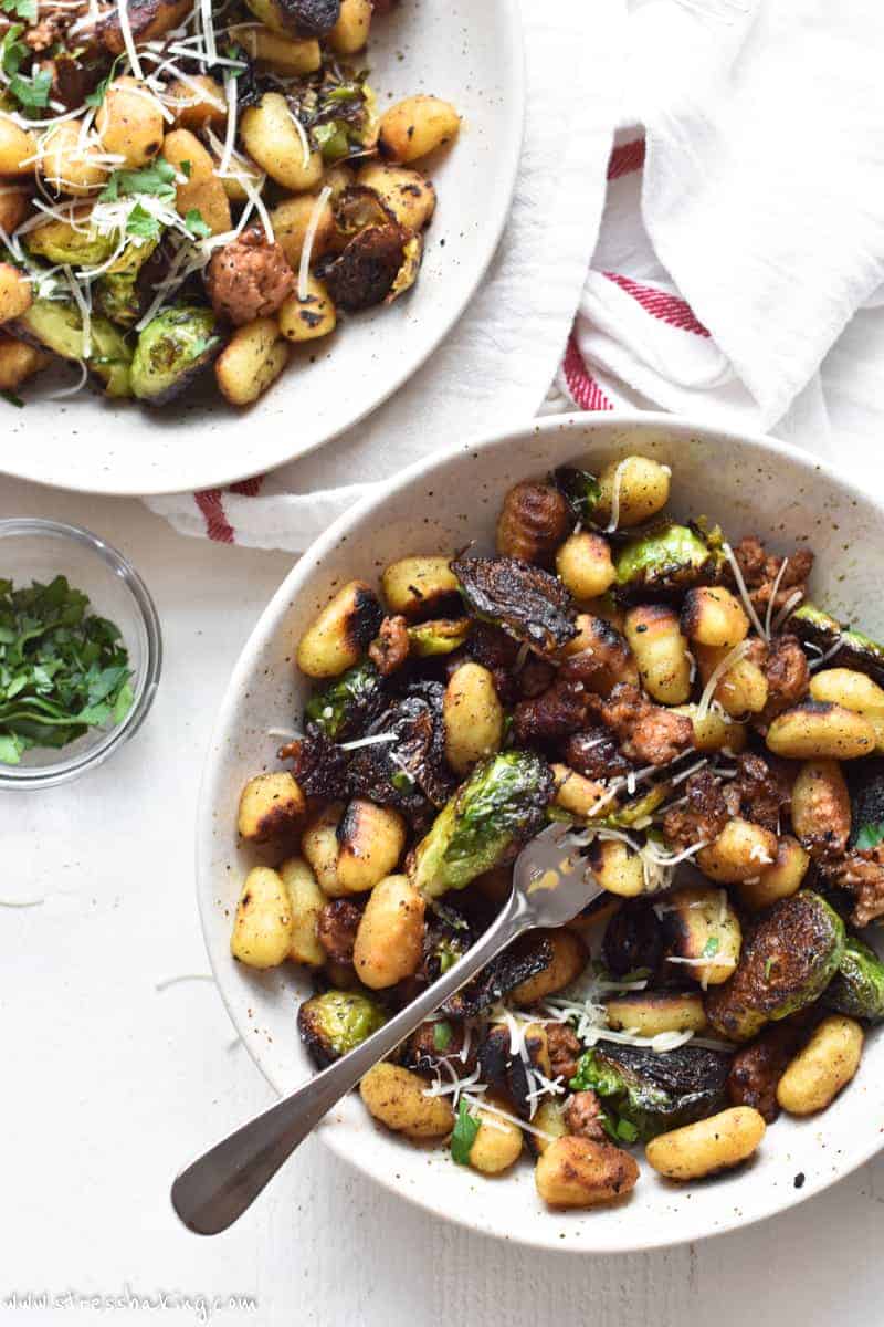 Two bowls of pan fried gnocchi and brussels sprouts