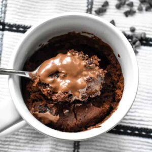 A heaping spoonful of chocolate mug cake with vanilla ice cream with melted Nutella