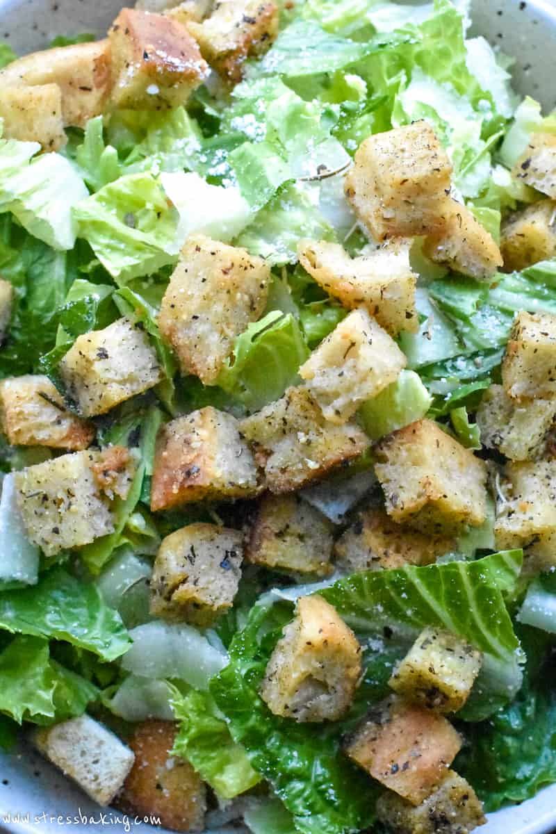 Homemade croutons on top a bright green Caesar salad