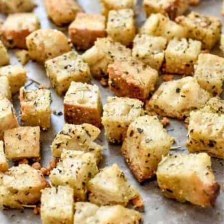 Freshly baked golden brown croutons on a baking sheet