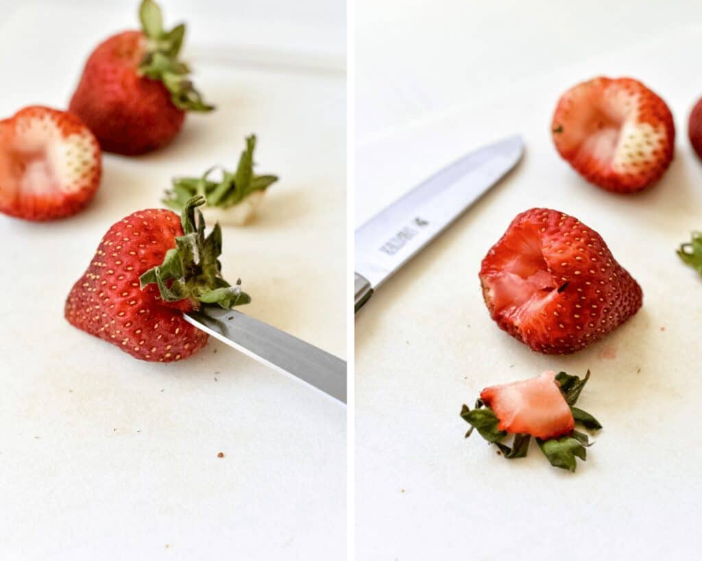 A strawberry being hulled with a pairing knife