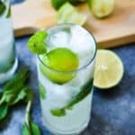 A freshly made mojito with bright green mint and limes