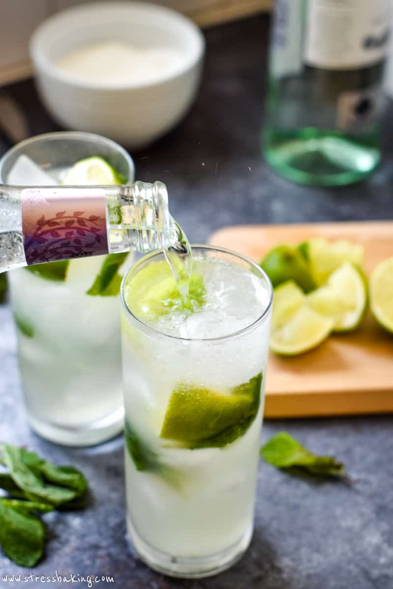Tonic water being poured into a glass of mojito