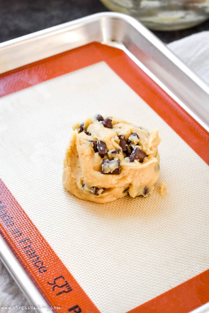 Mound of chocolate chip cookie dough on a half sheet pan
