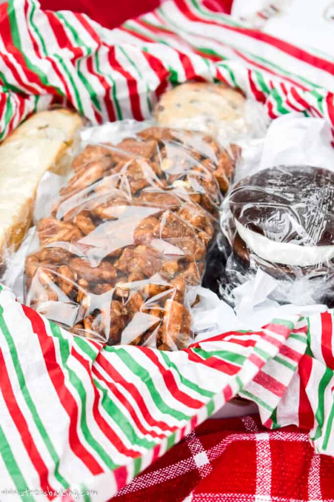 A holiday tin full of wrapped cookies and spiced nuts