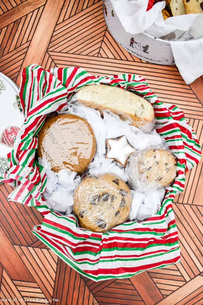 Cookies wrapped tightly in plastic wrap in a holiday tin