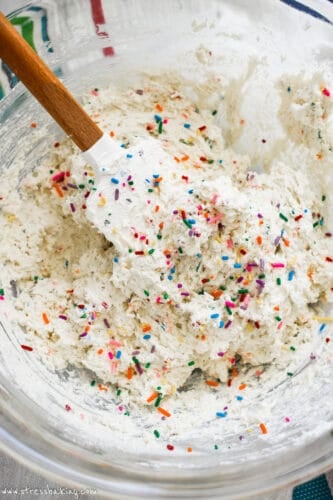A mixing bowl full of Dunkaroo Dip with rainbow sprinkles
