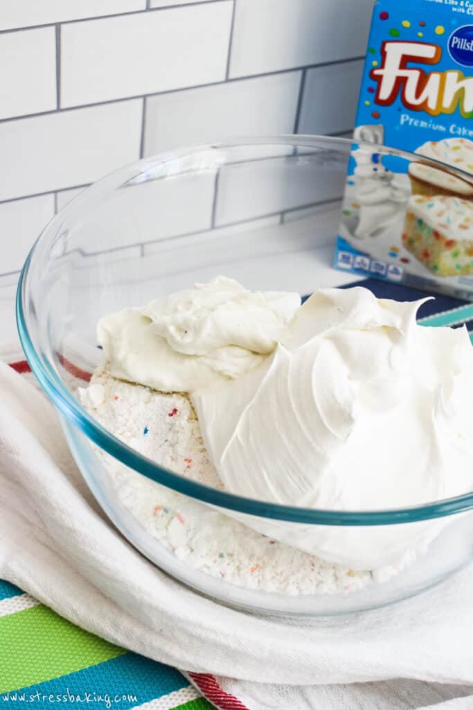 A mixing bowl full of funfetti cake mix, Cool Whip and yogurt
