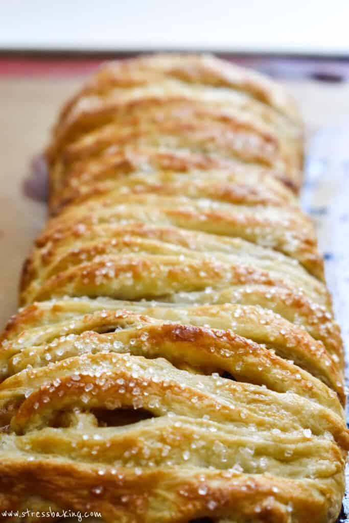 Golden pastry of braided apple strudel topped with sparkling sugar