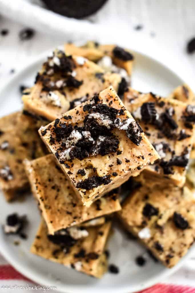 A stack of peanut butter fudge topped with crumbled Oreos