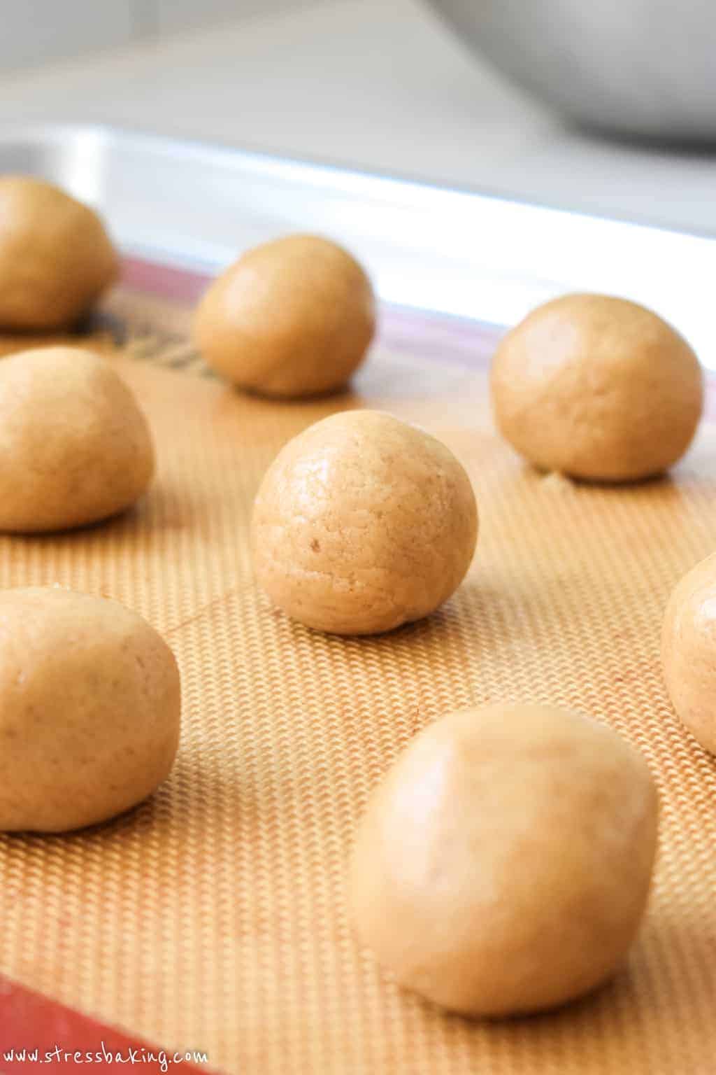 Smooth balls of tan colored dough on a baking sheet